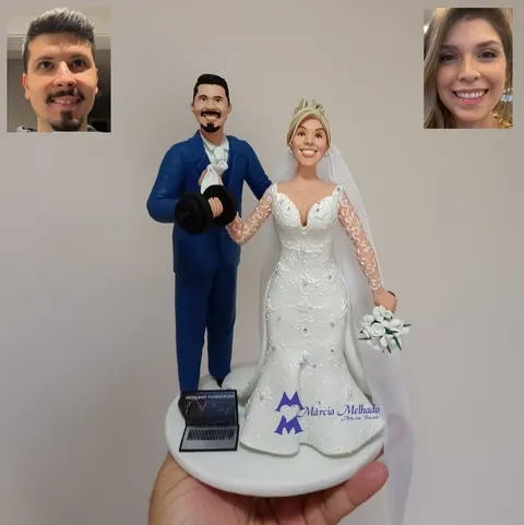 Noivinhos de biscuit: noivo de terno azul levantando um halter e noiva loira de vestido rendado, com notebook na base