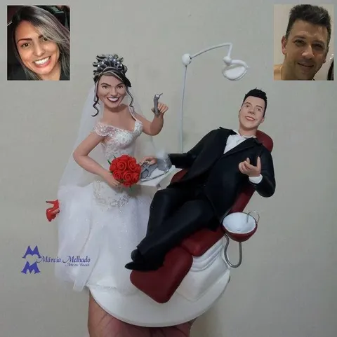 Noivinhos de biscuit: noiva dentista com buquê vermelho e noivo de terno preto deitado em cadeira odontológica vermelha