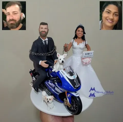 Noivinhos de biscuit: noivo em moto esportiva azul preso por corrente, noiva com plaquinha Sim, ele aceita e dois cachorros