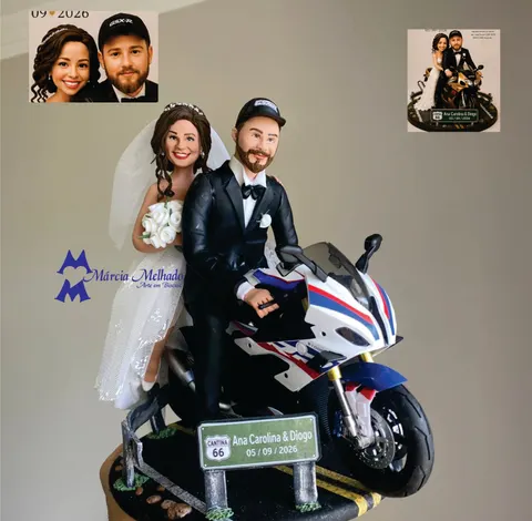 Noivinhos de biscuit em moto esportiva branca, noivo de boné e smoking pilotando e noiva de véu na garupa com buquê branco