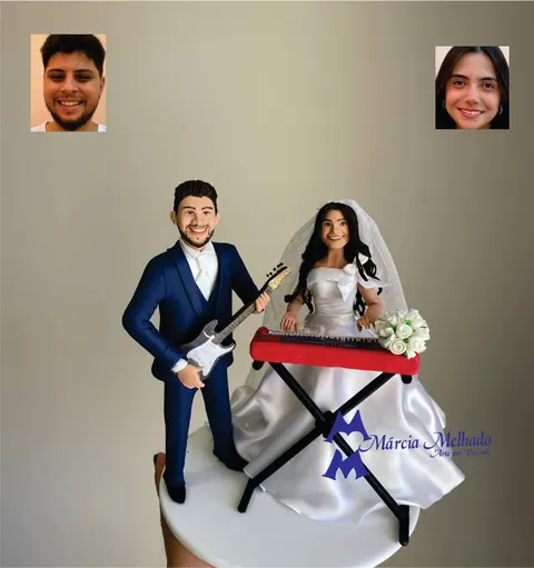 Noivinhos de biscuit: noivo de terno azul-marinho com guitarra e noiva de vestido branco e véu tocando teclado vermelho